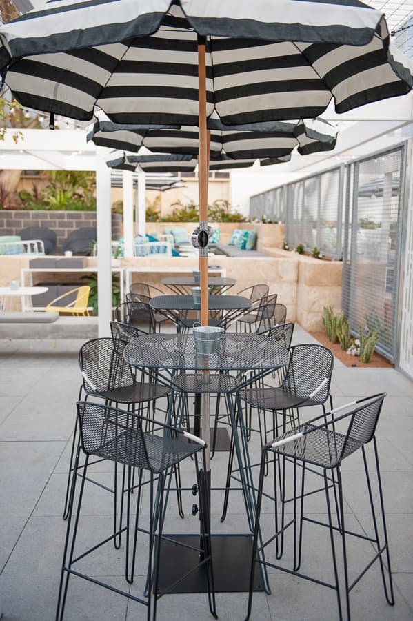 the Volley Bar Table is a modern outdoor bar table with a distinct mid-century modern vibe designed by Adam Goodrum.